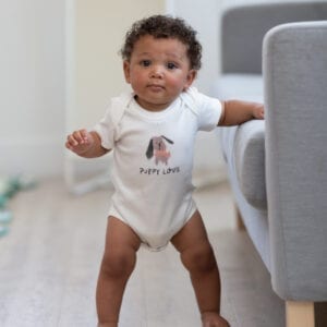 cute baby wearing off white short sleeve baby onesie with puppy graphic