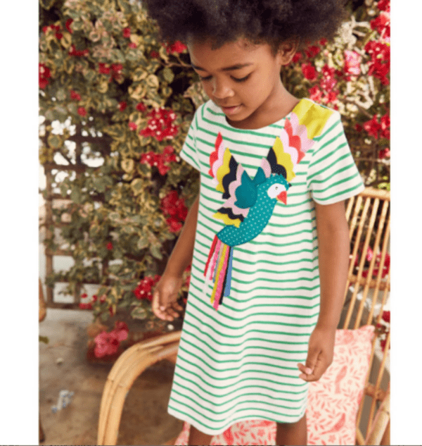 little girl wearing short sleeve green and white striped girls dress with colorful parrot